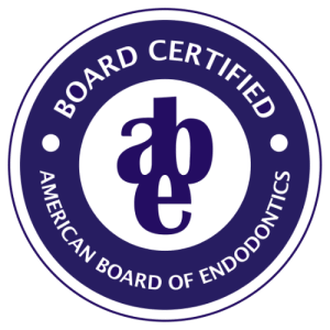 Circular badge seal reading 'BOARD CERTIFIED' and 'AMERICAN BOARD OF ENDODONTICS' with an 'abe' monogram in the center on a navy/purple background. Clean, professional credential badge suitable for trust-building sections.